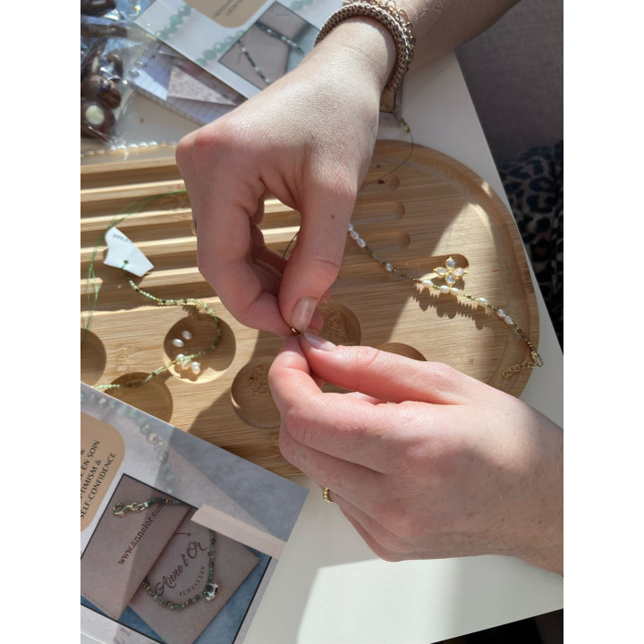 girl making their own Murmures Precieux® dash and dot jewellery DIY bracelet and necklace-making workshop
