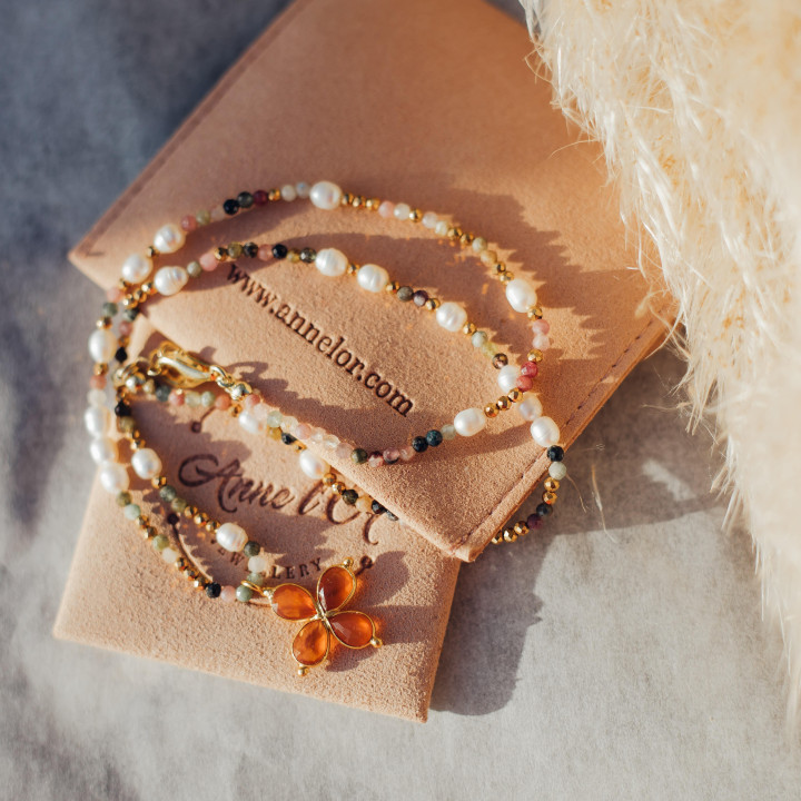 Collier Murmures Precieux® Bijoux créé avec l'alphabet Morse à murmures secrets en pierre fine tourmaline rose, perles de culture, enfilé à la main avec un pendentif en croix orange sur son étui avec pochette à velour