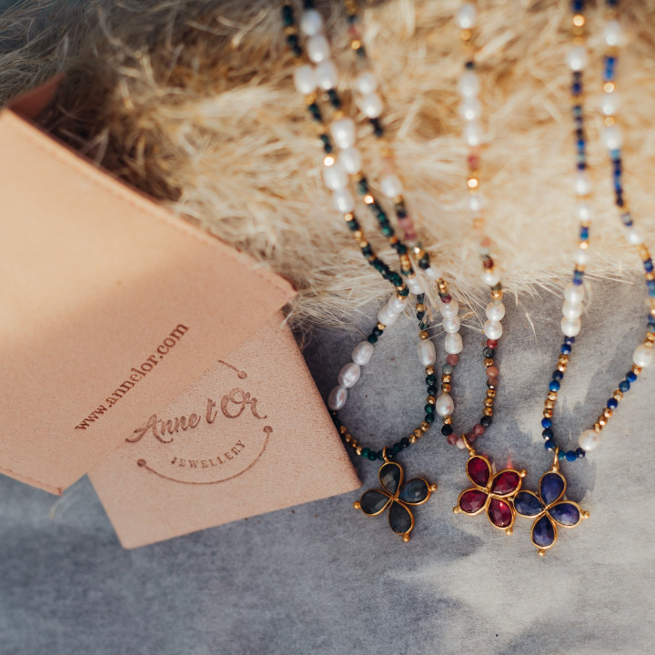 Murmures Precieux® dash and dot jewellery murmures secret necklaces handtheaded with in semi-precious stonecultured pearls encoded using Morse code, with a cross pendant with their pink velvet packaging with jewellery purse